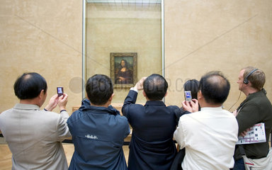 Paris  Touristen fotografieren das Gemaelde der Mona Lisa im Louvre