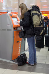 Berlin  Frau an einem Quick-Check-In-Automat der Airline easy Jet