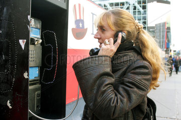New York  eine Frau telefoniert an einem oeffentlichen Fernsprecher