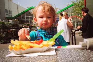 Berlin  ein Junge isst seine Pommes Frites mit Ketschup