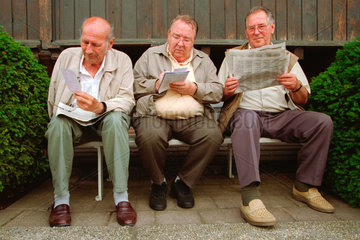 Dresden  drei Rentner sitzen auf einer Bank und lesen