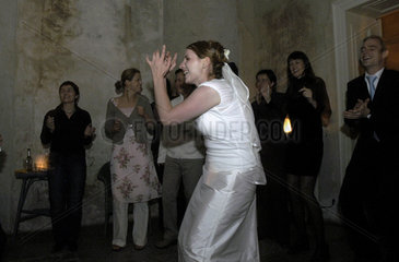 Eine Braut tanzt ausgelassen auf ihrer Hochzeit