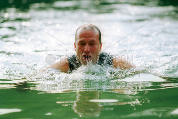 Ein Mann schwimmt in einem See