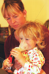 Eine Mutter hilft ihrem Kind beim Inhalieren