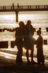 Eine Familie im Gegenlicht am Strand