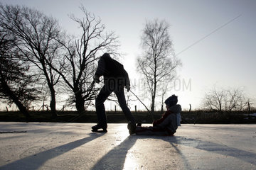 Prangendorf  Mann und Kind beim Schlittschuhlaufen auf einem zugefrorenen See