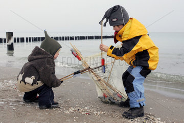Zingst  Kinder sammeln abgebrannte Silvesterraketen am Strand ein