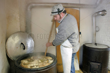 Prangendorf  Mann kocht Wellfleisch in einem Kessel