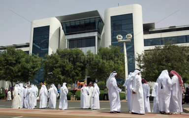 Dubai  arabische Maenner vor dem Eingang zur Galopprennbahn Nad al Sheba