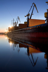 Wismar  Containerschiff und Verladekraene im Hafen am Abend
