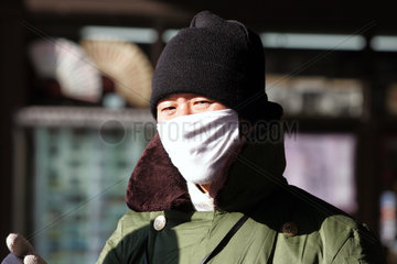 Peking  Mann mit Mundschutz auf einer Strasse