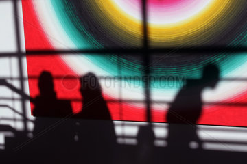 Peking  Silhouetten von Menschen vor farbigem Hintergrund