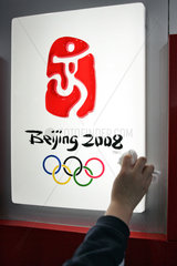 Ein Schild mit dem Logo der Olympischen Sommerspiele 2008 wird geputzt