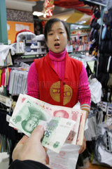 Peking  der Verkaeuferin wird Geld gereicht