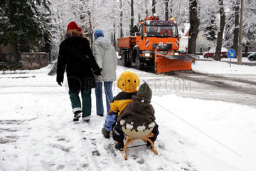 Neuenhagen  Muetter ziehen ihre Kinder auf einem Schlitten durch die Strassen