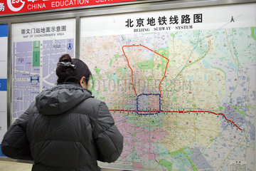Peking  Frau studiert das Liniennetz der U-Bahn