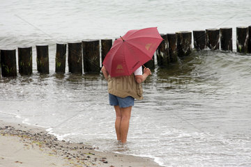 Heiligendamm  Mann mit Regenschirm steht im Wasser