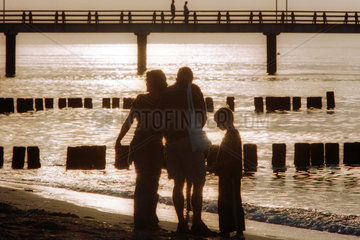 Eine Familie im Gegenlicht am Strand