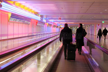 Muenchen  Reisende in einem Gang des Flughafen auf einer Rolltreppe