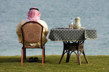 Abu Dhabi  arabischer Mann macht ein Picknick am Wasser