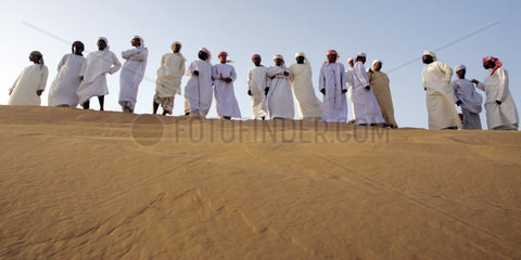 Dubai  eine Gruppe arabischer Maenner in der Wueste