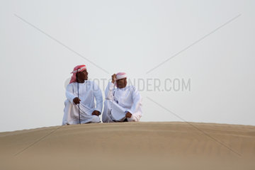 Dubai  arabische Maenner in der Wueste