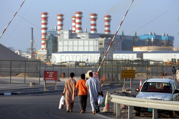 Dubai  arabische Maenner vor der DEWA Power Station