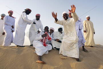 Dubai  eine Gruppe arabischer Maenner in der Wueste