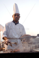 Dubai  ein Koch legt Speisen auf einen Teller