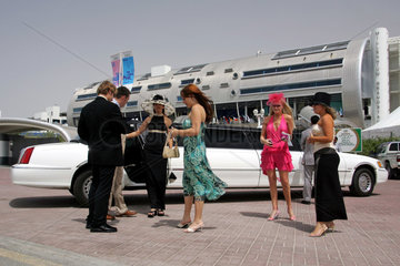 Dubai  elegant gekleidete Frauen und Maenner vor dem Eingang zur Galopprennbahn Nad al Sheba