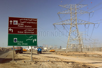 Dubai  Strommasten und Wegweiser in der Wueste