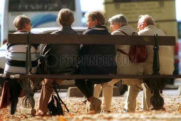 Rentner sitzen auf einer Bank und unterhalten sich