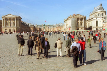 Touristen spazieren vor dem Versailler Schloss