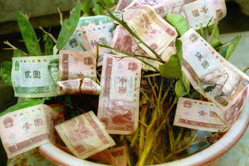 Chinesische Geldscheine in einem Spendentopf