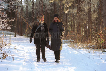Zwei Frauen beim Spaziergang in einer Winterlandschaft