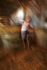 Ein Kind springt ins Heu auf dem Bauernhof