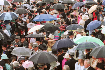 Zuschauer mit Hut und Zylinder im Regen auf der Galopprennbahn Royal Ascot