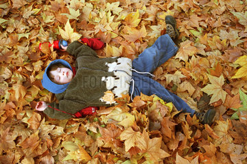 Symbolfoto eines Kindes im Herbstlaub