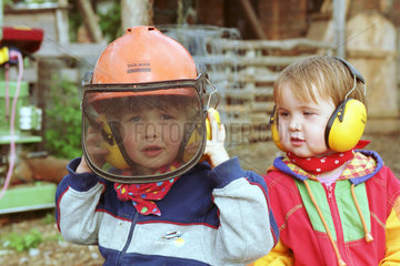Zwei Kinder mit Gehoerschutz auf dem Bauernhof