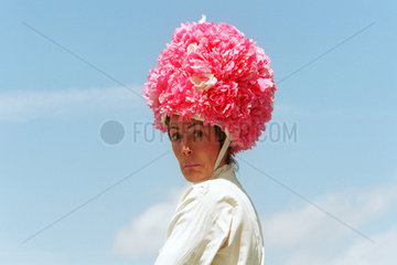 Frau mit einem extravaganten Hut auf der Galopprennbahn Epsom Downs