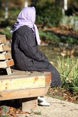 Odessa  eine Frau mit Kopftuch sitzt auf einer Bank
