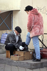 Odessa  eine Frau laesst sich die Schuhe putzen