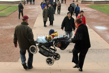 Dresden  Eltern tragen einen Kinderwagen eine Treppe hinunter