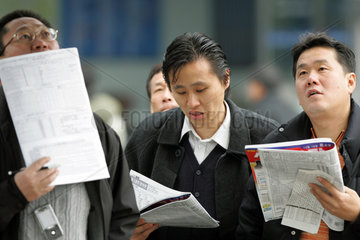 Seoul  Menschen lesen in Wettzeitungen