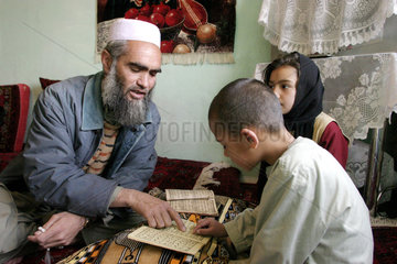 Koranschueler werden von einem Imam unterrichtet
