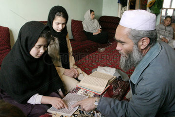 Koranschuelerinen werden von einem Imam unterrichtet