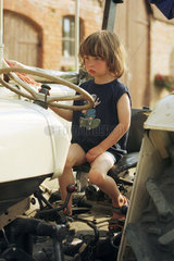 Ein Kind sitzt auf einem Traktor