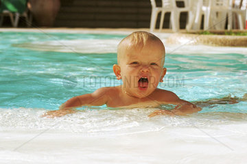 Ein Kind beim Schwimmen im Swimmingpool