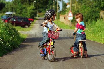 Mecklenburg  Strassenverkehr - Kinder mit Fahrraedern auf der Dorfstrasse
