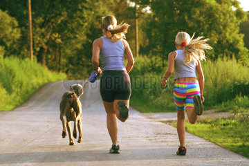 Mutter und Tochter joggen im Wald